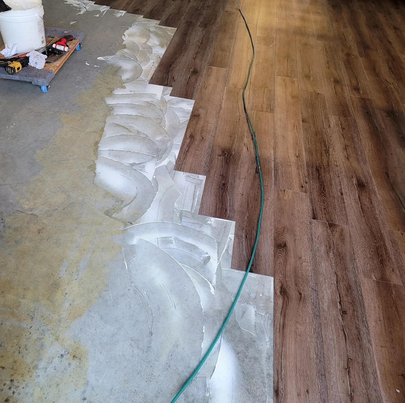 Plank flooring being installed over a prepared concrete subfloor