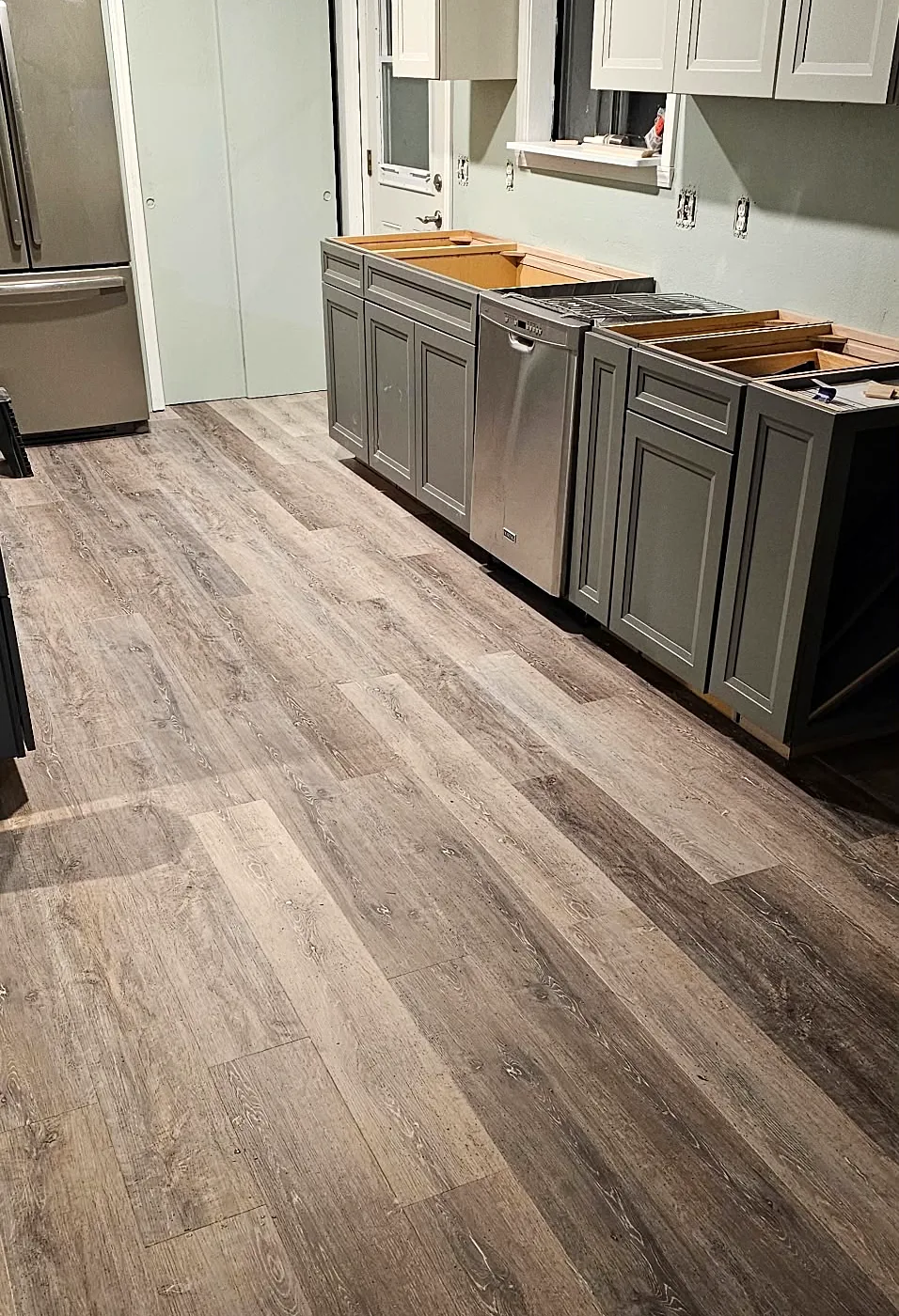 Kitchen with gray base cabinets and new plank flooring